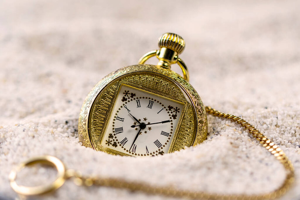 Taschenuhren, alte goldene Armbanduhr im Sand bei Tageslicht. - Foto, Bild