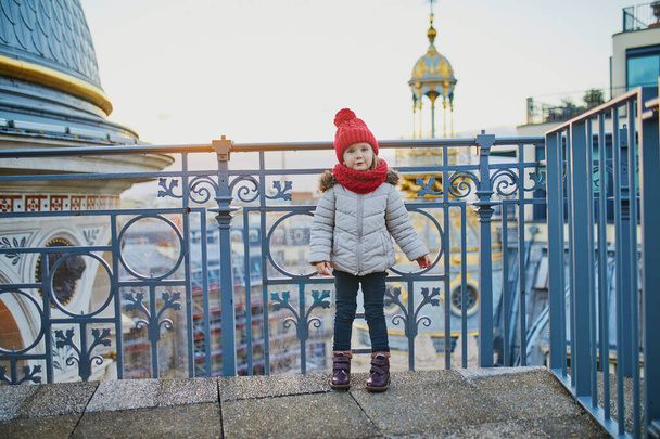 Adorable little girl enjoying view to Parisian skyline with roofs and the Eiffel tower - Foto, imagen