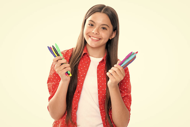 Schulmädchen mit bunten Bleistiften auf weißem Hintergrund. Porträt eines glücklich lächelnden Teenagerkinds - Foto, Bild