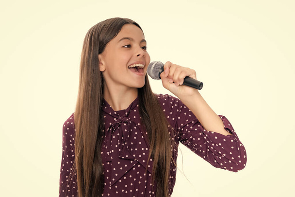 Egy tinédzser mikrofonnal énekel. Karaoke énekes. A tinilány énekel. Gyermek zenész hangosan. Egy boldog, mosolygós tinédzser lány portréja - Fotó, kép