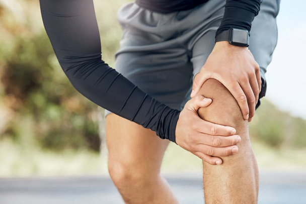 Mein Knie tut richtig weh. ein sportlicher junger Mann, der beim Laufen Beschwerden im Knie hat - Foto, Bild