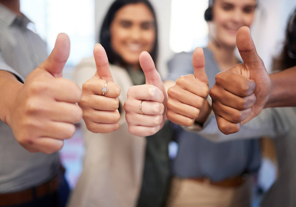 Youll have many rewards to enjoy if you work hard. Closeup shot of a group of unrecognisable businesspeople showing thumbs up in an office - Photo, image