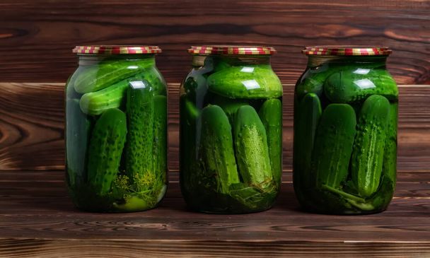 Preservations, conservation. Salted, pickled cucumbers in a jar on an old wooden table. Cucumbers, herbs, dill, garlic. Rustic. Background - Foto, Imagem