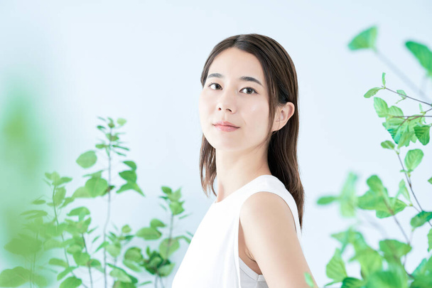 young woman with white clothes surrounded by plants - Photo, Image