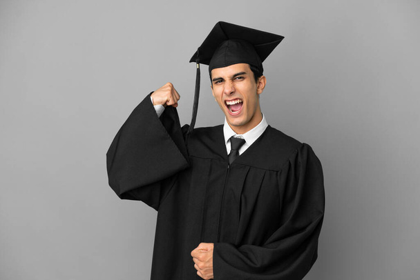 Молодой аргентинский выпускник университета изолирован на сером фоне, делая сильный жест - Фото, изображение