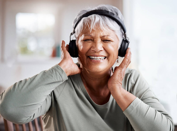 Żyj i pozwól żyć. piękna seniorka słuchająca muzyki siedząc na kanapie w domu - Zdjęcie, obraz