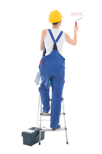 back view of young woman painter in blue coveralls standing on l - Foto, Imagem