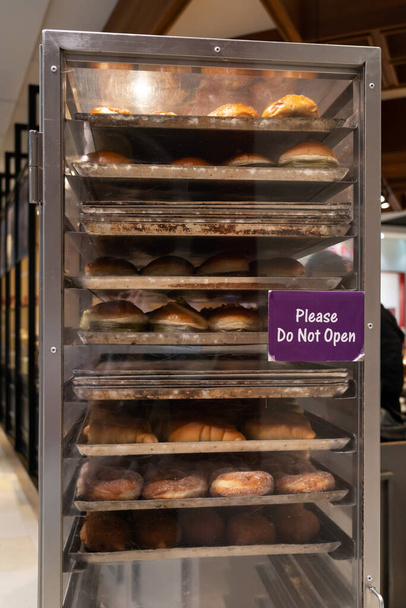 Rack trolley with freshly baked bread at supermarket. - Foto, Imagen