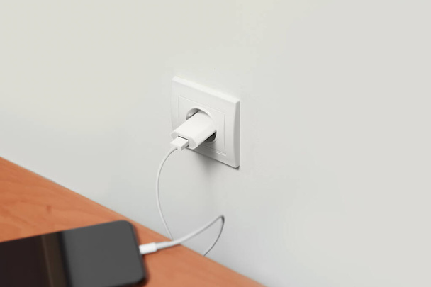 Modern smartphone charging from electric socket indoors - Fotoğraf, Görsel