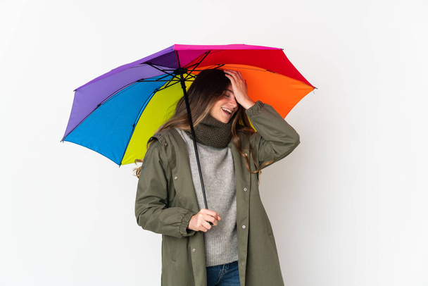 Mladá běloška, která drží deštník izolovaný na bílém pozadí, si něco uvědomila a zamýšlí řešení - Fotografie, Obrázek