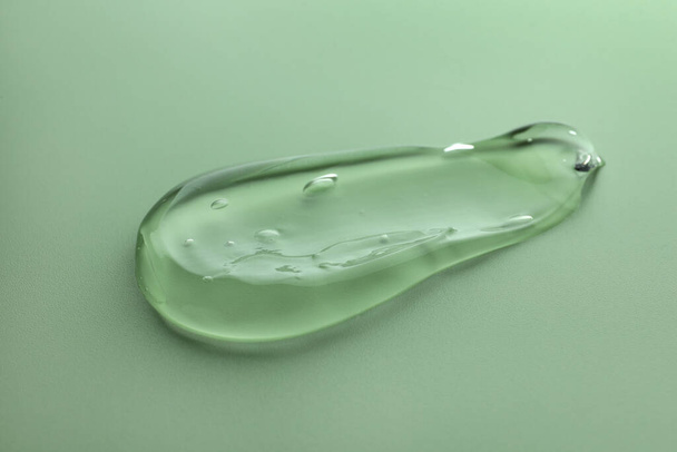 Sample of transparent gel on green background - Fotoğraf, Görsel