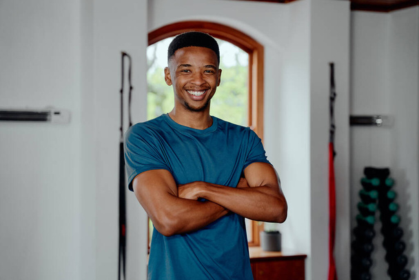 Portrait of happy young black man in sportswear looking at camera at the gym - Foto, Imagem