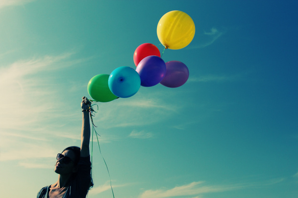 Женщина держит цветные воздушные шары - Фото, изображение