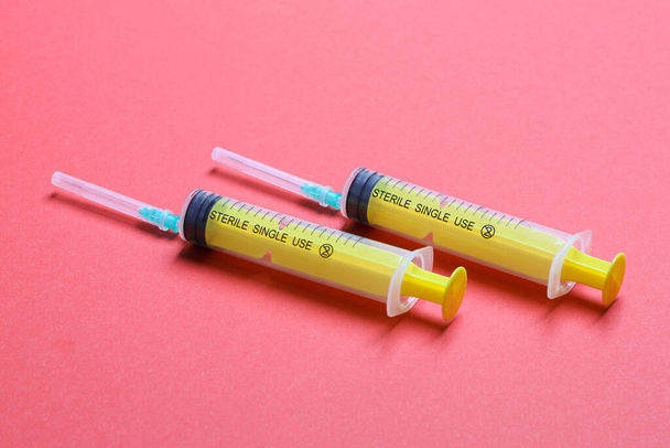 A fecskendők felülnézete egy sorban orvosi injekcióhoz színes háttérrel, fénymásoló felülettel. Egészségügy és vakcinázás. - Fotó, kép