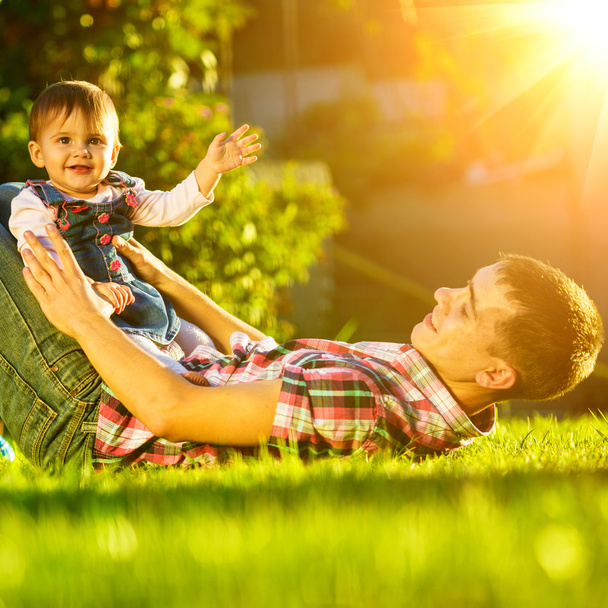 Father and baby daughter having fun in sunny garden. - Photo, image