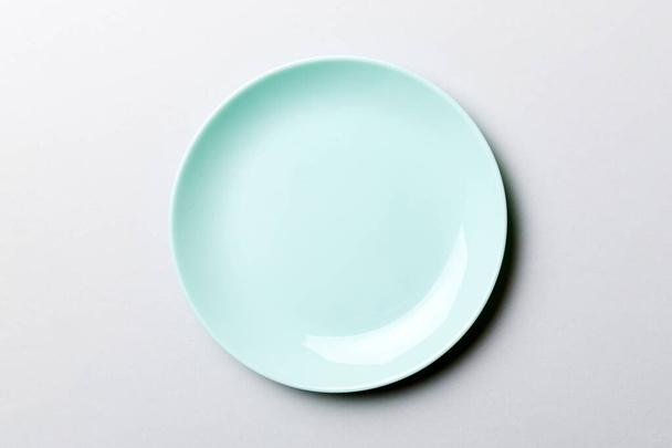 Horní pohled na izolované barevné pozadí prázdný kulatý modrý talíř pro potraviny. Prázdné misky s prostorem pro váš design. - Fotografie, Obrázek