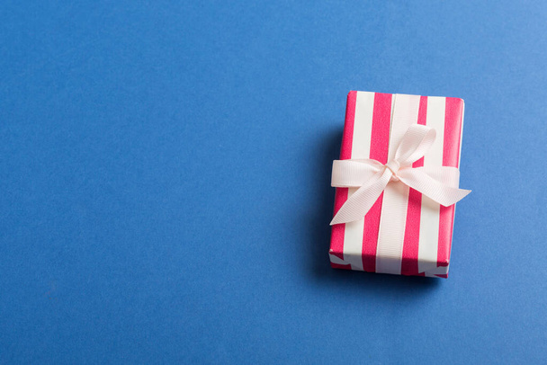 emballage de Noël ou autre boîte cadeau faite à la main de vacances en papier de couleur avec ruban sur fond coloré. Coffret cadeau, décoration de cadeau sur table colorée, vue de dessus avec espace de copie. - Photo, image