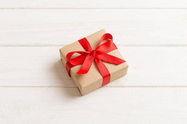 Csomagolt karácsonyi vagy más ünnep kézzel készített ajándék kézműves papír színes szalaggal. Jelen doboz, ajándék dekoráció az asztalon, felülnézet másolási hellyel. - Fotó, kép