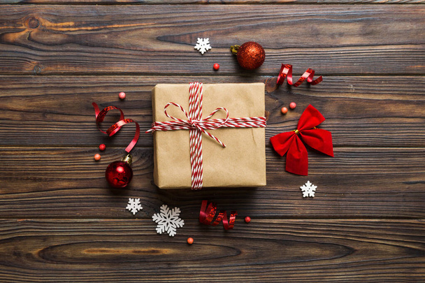 Зверху - різдвяні прикраси і коробка з подарунками на кольоровому фоні з копіювальним простором. Різдво або з новорічною композицією. - Фото, зображення