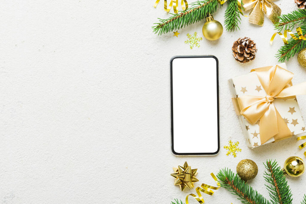 Digital phone mock up with rustic Christmas decorations for app presentation top view with empty space for you design. Christmas online shopping concept. Tablet with copy space on colored background. - Foto, Imagen