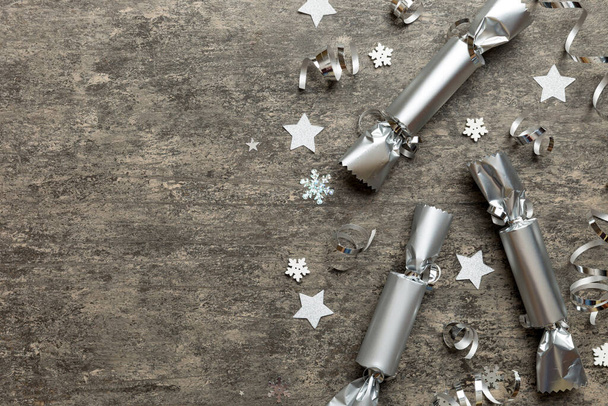 Christmas crackers with shiny confetti on color background, top view, copy space. - Fotó, kép