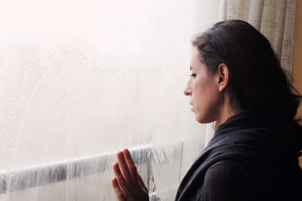 Mujer de pie frente a la ventana
 - Foto, Imagen