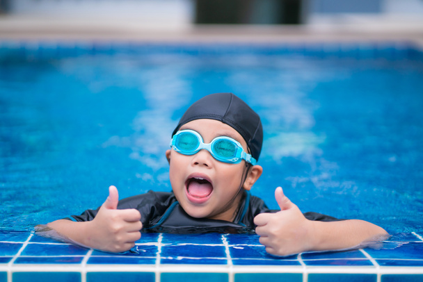 χαρούμενα παιδιά Χαμογελώντας χαριτωμένο κοριτσάκι με γυαλιά ηλίου στην πισίνα. - Φωτογραφία, εικόνα