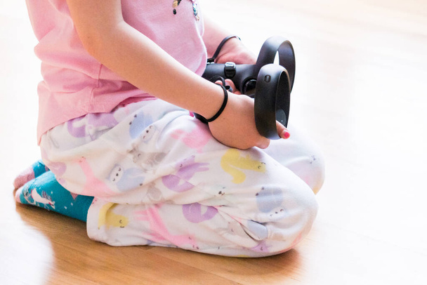 Little girl playing virtual reality game in the living room, - Photo, Image