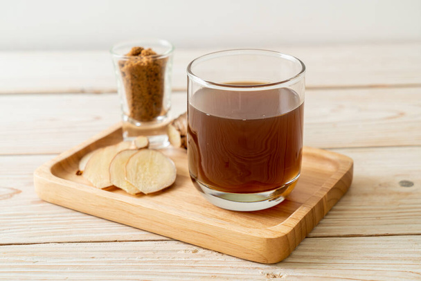 hot and sweet ginger juice glass with ginger roots - Healthy drink style - Foto, imagen