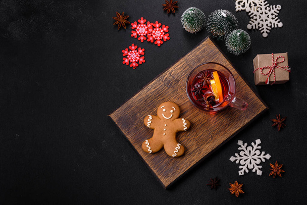 Joulu glögiä punaviiniä mausteilla ja hedelmillä betonipöydällä. Perinteinen kuuma juoma jouluna - Valokuva, kuva
