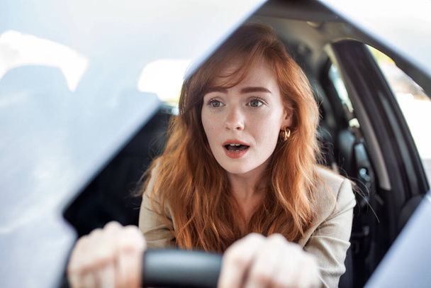 Nuori kauhuissaan oleva nainen ajaa ja joutuu auto-onnettomuuteen. Aikuinen nainen ajaa ja näyttää pelokkaalta ja yllättyneeltä hänen edessään olevalla tiellä. Nainen auto-onnettomuudessa - Valokuva, kuva