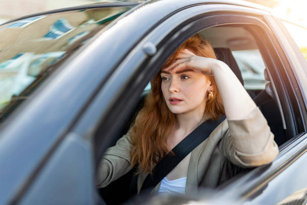 Нервная женщина-водитель садится за руль, обеспокоенная выражением лица, так как боится водить машину в одиночку в первый раз. Испуганная женщина попала в аварию на дороге. Люди, вождение, проблемы с транспортом
 - Фото, изображение