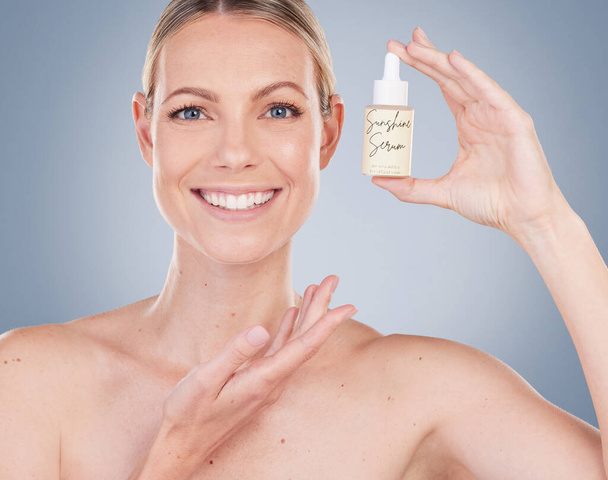 Does what it says on the label. Studio portrait of an attractive young woman posing with facial serum against a grey background - Foto, Imagem
