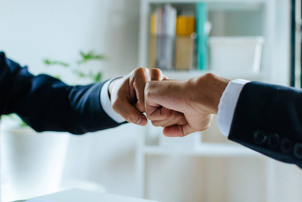 Negotiation. businessman investor hand to fist bumping and joining hands together after complete business deal in meeting room at home office, partnership, teamwork corporate and financial concept - Valokuva, kuva