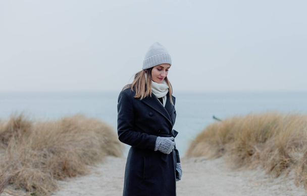 Woman on Baltic Sea beach in winter with contemplative mood - Foto, afbeelding