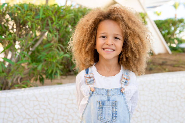 Retrato de cerca de una niña sonriente en el parque de primavera en un día soleado y cálido. - Foto, Imagen
