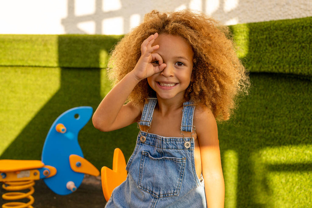 Παιχνιδιάρικο πορτρέτο κοριτσάκι στο πάρκο, χαμογελώντας και παίζοντας σε εξωτερικούς χώρους της φύσης. - Φωτογραφία, εικόνα
