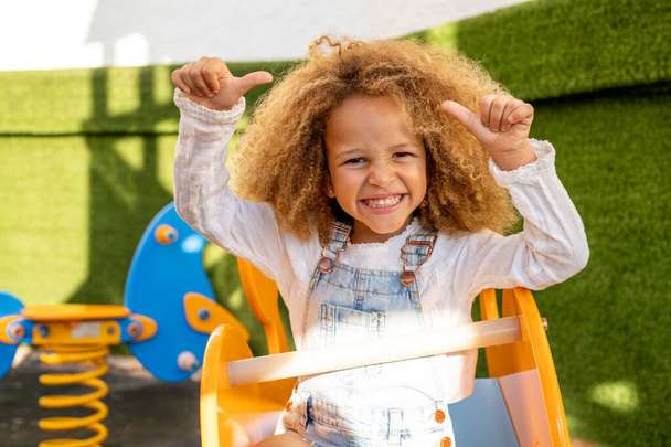 Активна красива маленька дівчинка на дитячому майданчику на відкритому повітрі
. - Фото, зображення