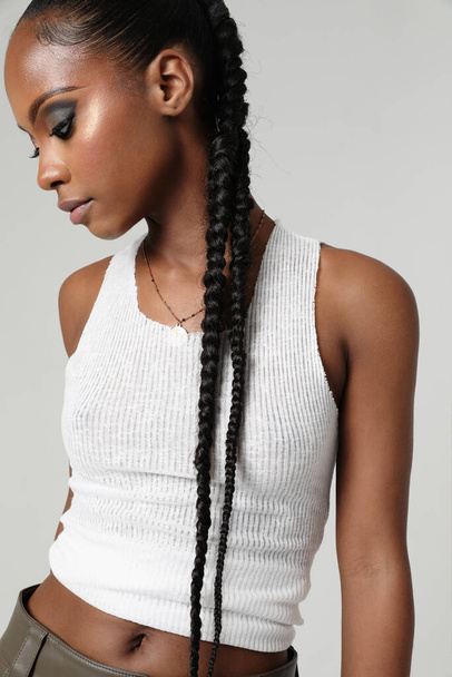 Cropped portrait of young beautiful woman with braids hairstyle posing indoor. High quality photo. - Φωτογραφία, εικόνα