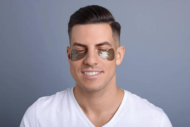 Man with dark under eye patches on grey  background - Fotó, kép