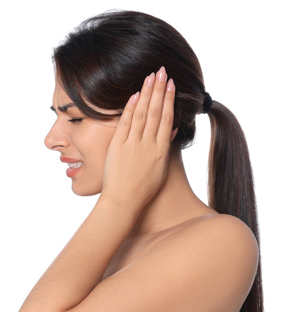 Young woman suffering from ear pain on white background - Photo, image