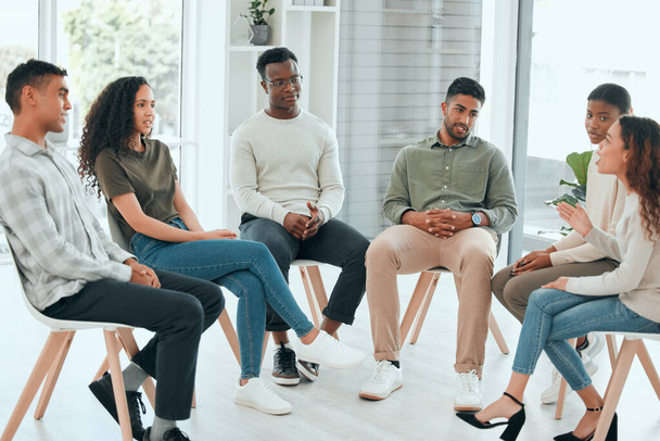 Aprende a compartir tus experiencias. un grupo diverso de personas sentadas juntas y hablando durante la terapia de grupo - Foto, imagen