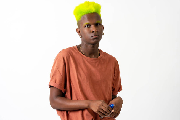 An androgynous black man posing in a studio on a white background, LGTBI concept, portrait with green hair - Photo, Image