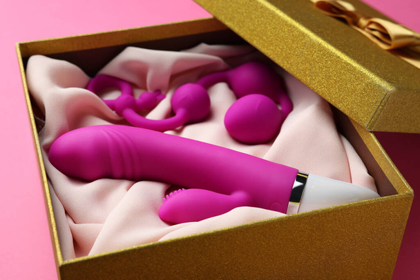 Sex toys in gift box on pink background, closeup - Foto, afbeelding