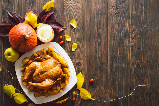 Frohes Thanksgiving. Herbstliche Komposition mit Blättern, reifem Kürbis und Thanksgiving Truthahn auf einem dunklen Holztisch. Ansicht von oben. - Foto, Bild