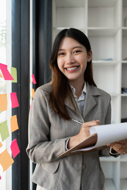 Mądra azjatycka bizneswoman uśmiechnięta do powierzchni biurowej. nieruchomości, adwokat, non-profit, marketing. - Zdjęcie, obraz
