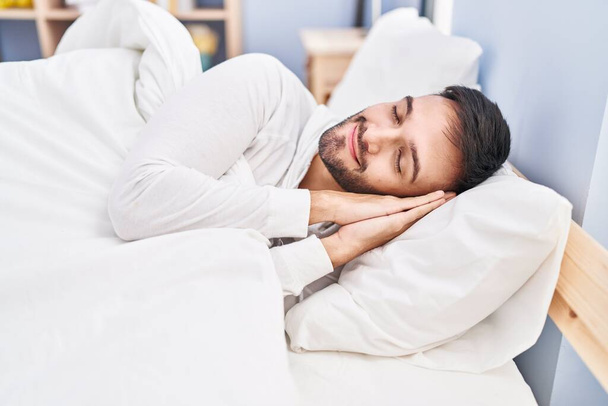 Genç İspanyol adam yatakta uzanıp yatak odasında uyuyor. - Fotoğraf, Görsel