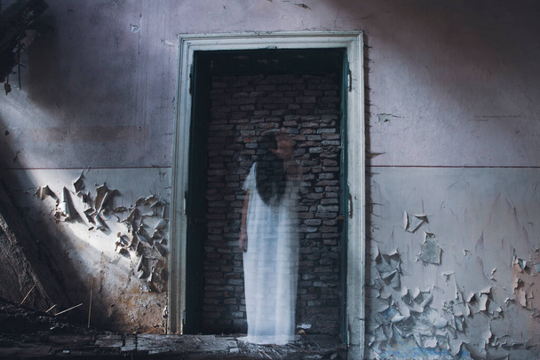 Ghost in abandoned, haunted house. Horror scene of scary spirit of a woman, halloween concept. - Foto, Imagem