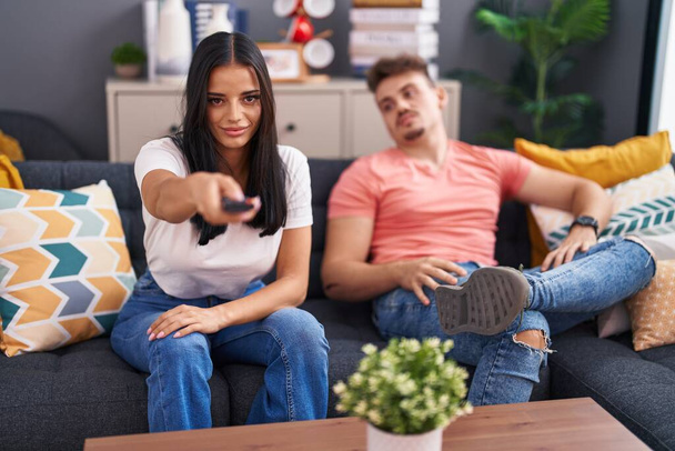 Ehepaar sitzt zu Hause auf Sofa vor dem Fernseher - Foto, Bild