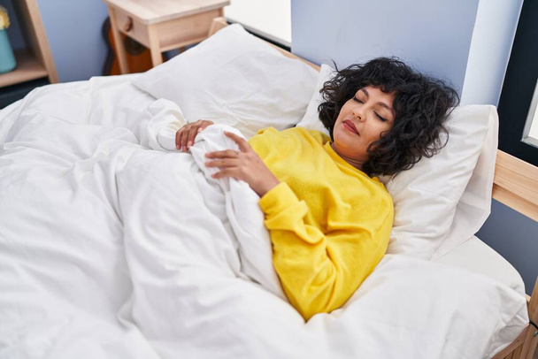 Nuori kaunis latino nainen makaa sängyllä nukkumassa makuuhuoneessa - Valokuva, kuva